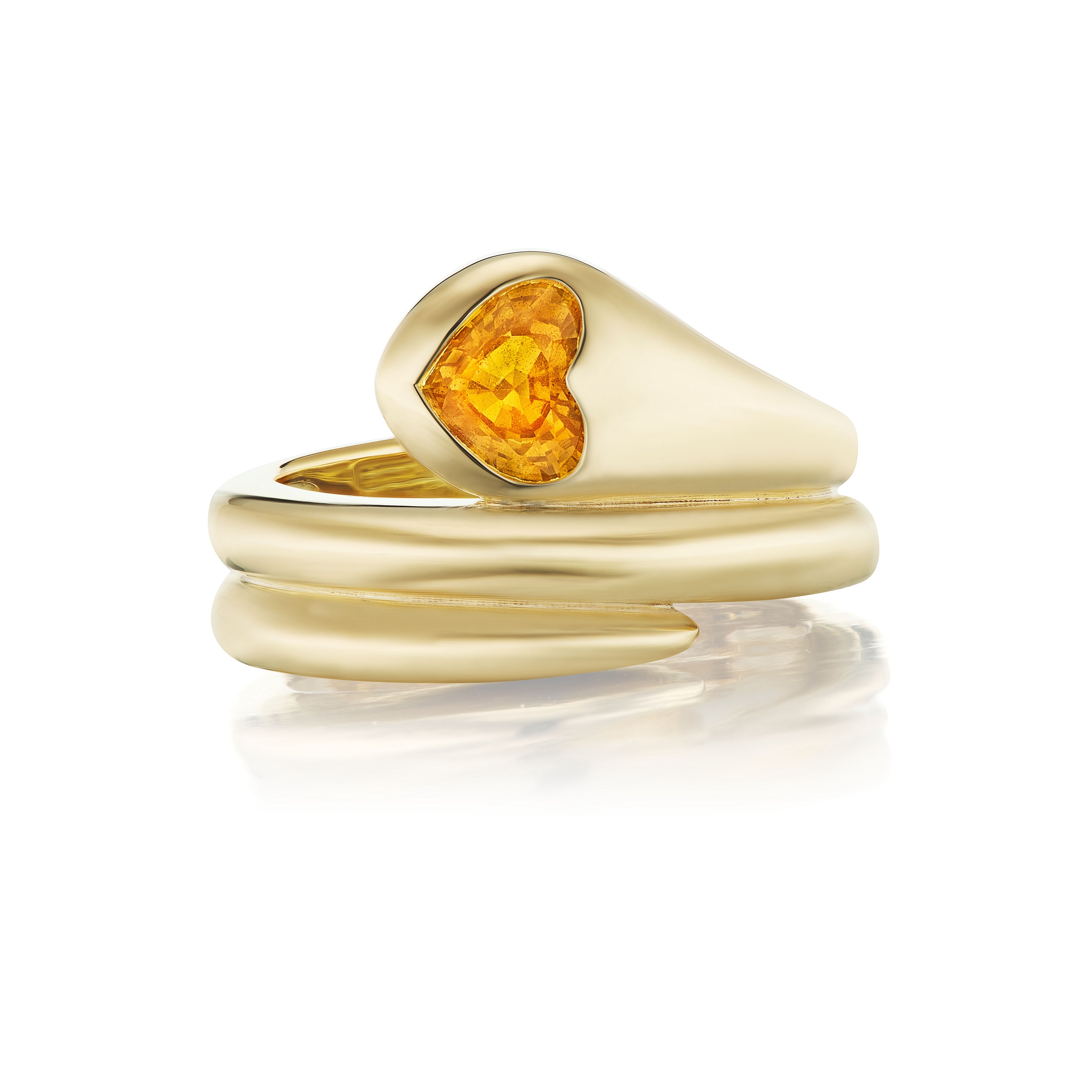 The Wraparound Snake Ring in 18K Yellow Gold showcases a modern design with an orange heart-shape sapphire at the top. Its layered band creates a stacked look, and the ring is displayed on a white background.