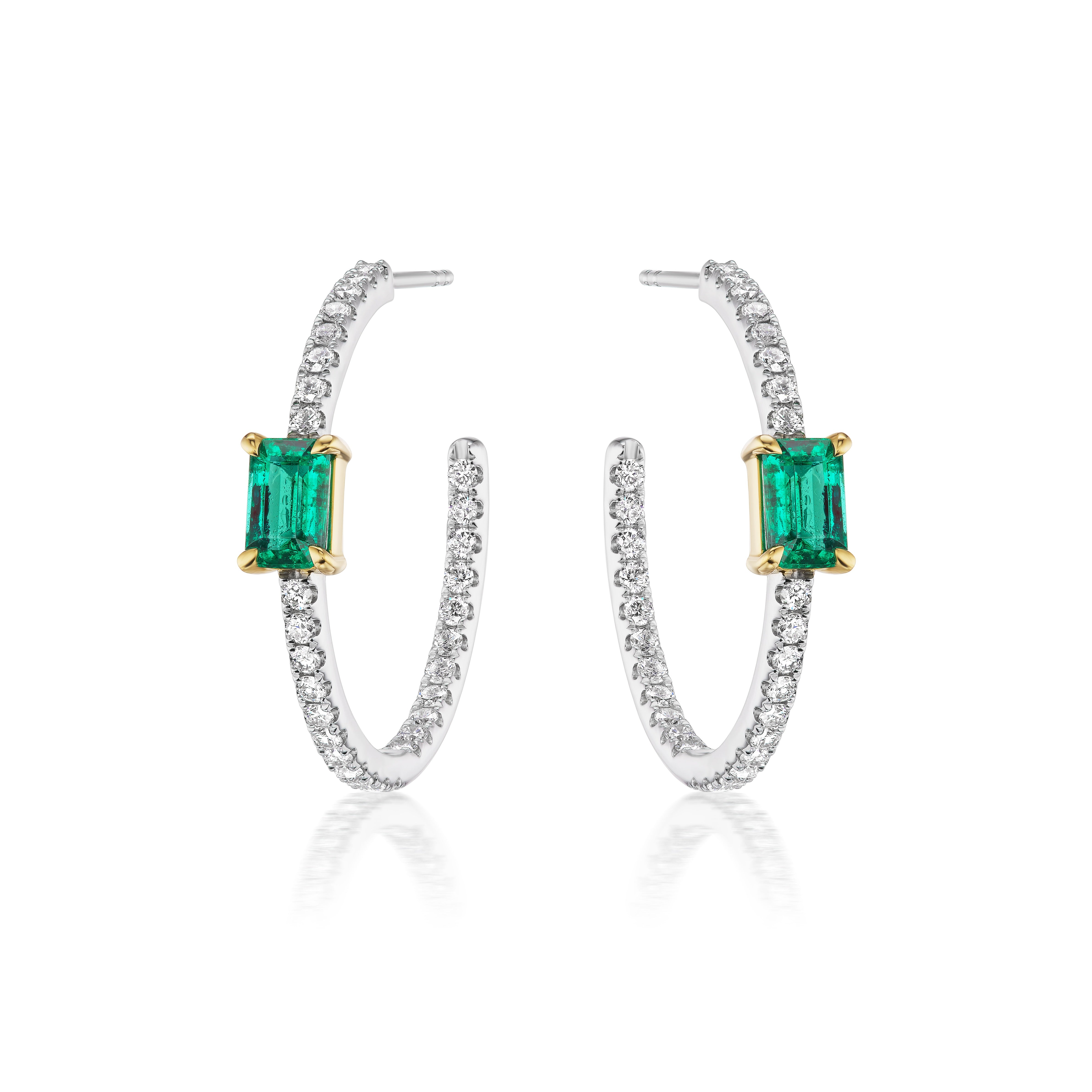 The Pavé Hoops with Emerald Cut Emeralds in White Gold feature emerald cut emeralds set in white gold prongs, with pavé diamond detailing on the hoops, shown against a white background.
