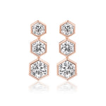 The Graduated Hexagon Bezel Set Drop Earrings feature three round brilliant diamonds in hexagonal bezel settings, arranged vertically by size and crafted in radiant 18K yellow gold.