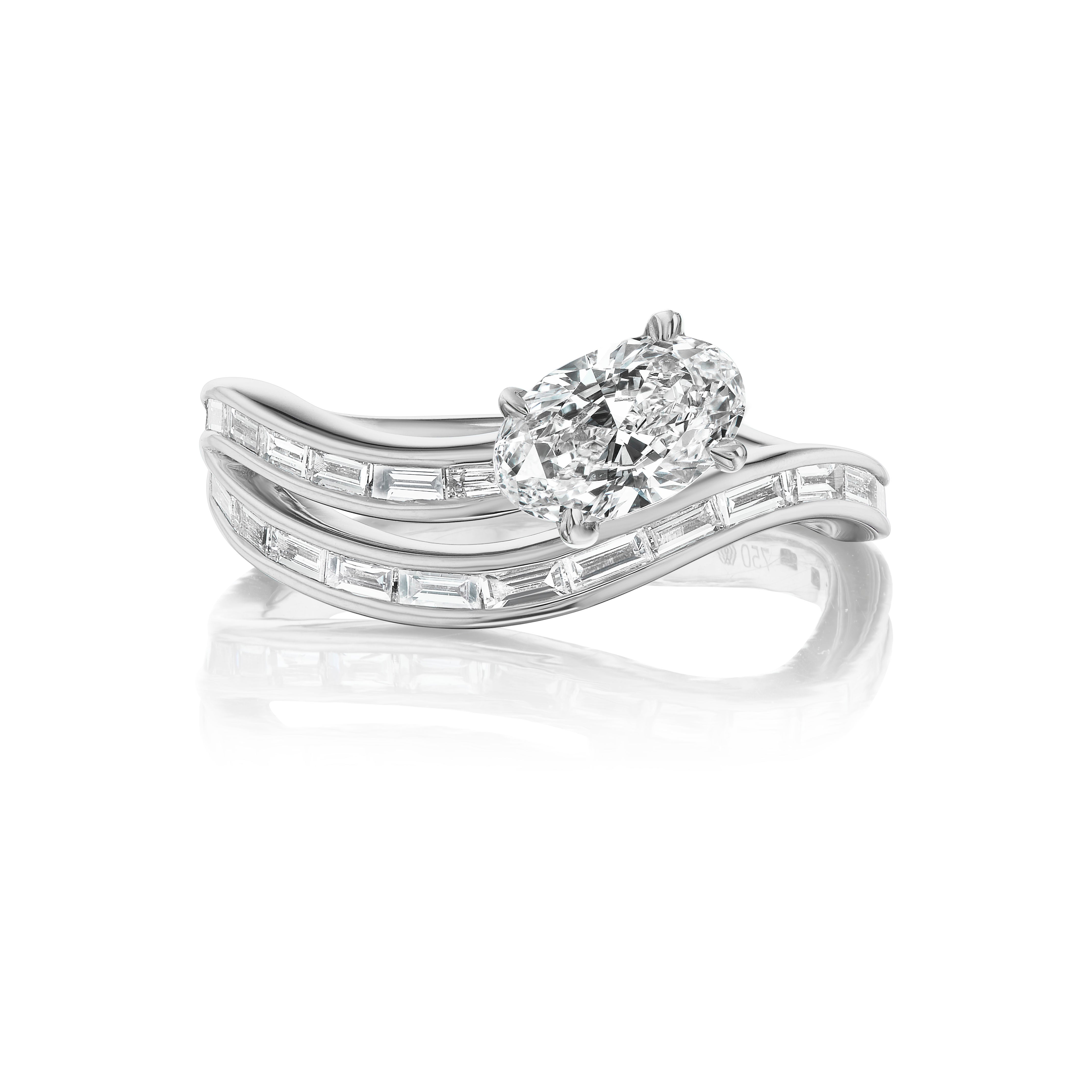 The Snake Wave Channel Set Baguette Diamond Ring features an oval center diamond and two curved bands with channel-set baguette diamonds, elegantly displayed on a white background.