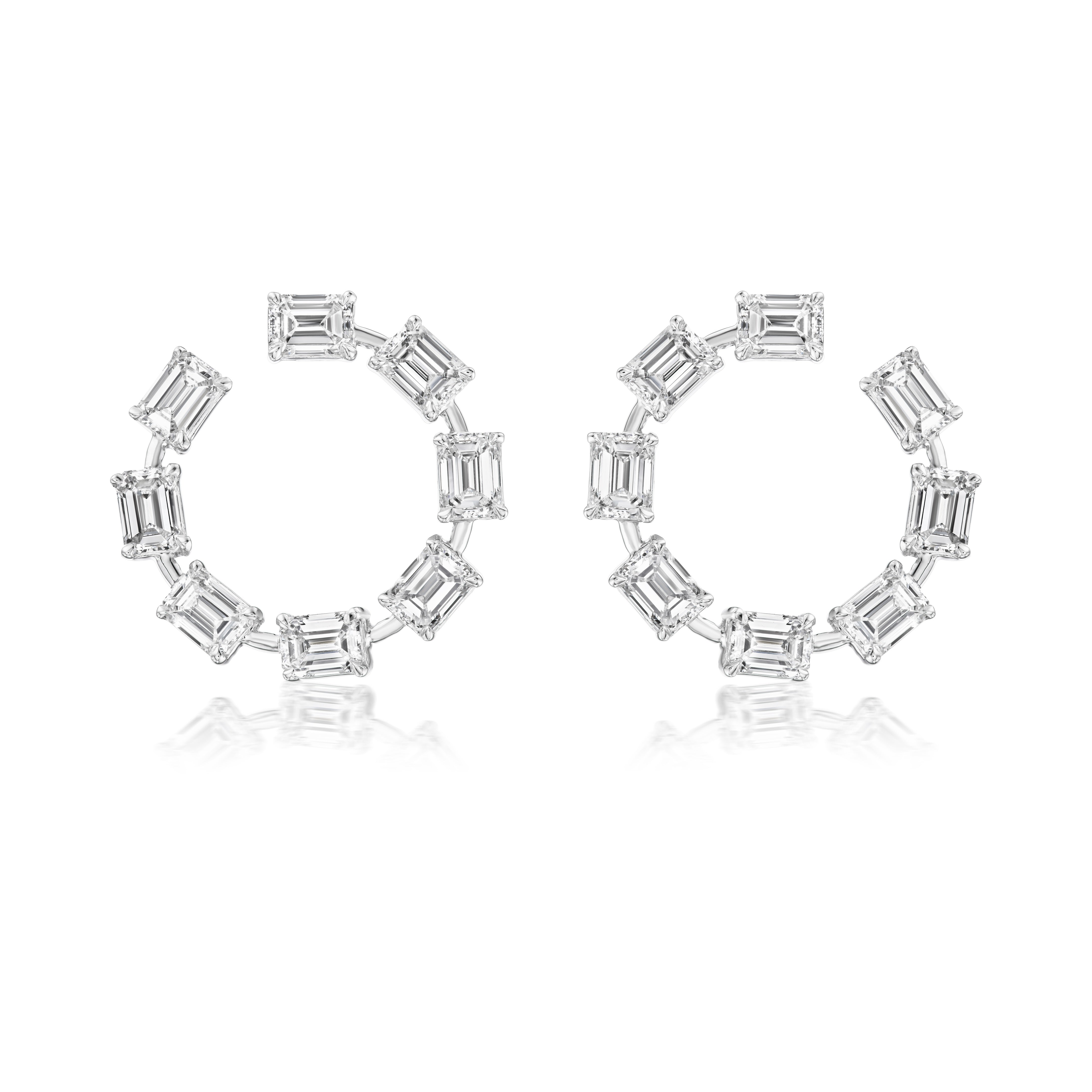 Emerald Cut Diamond Front to Back Hoop Earrings in White Gold, featuring emerald-cut clear gemstones set evenly around each circular hoop, are displayed on a white background with a subtle reflection below.