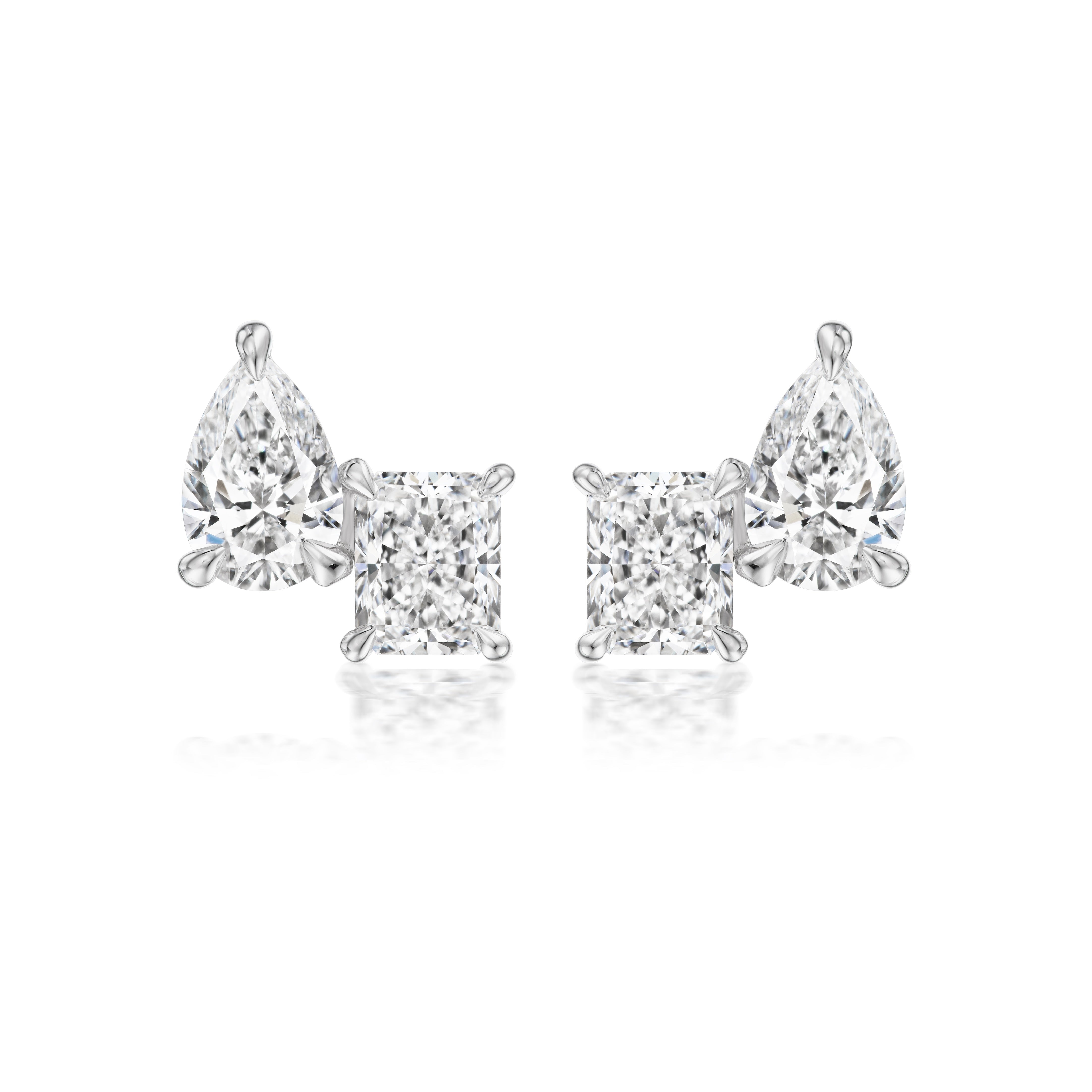 The Mixed Shape Duo Studs feature radiant cut and pear-shaped diamonds set in 18k white gold, displayed on a white background.