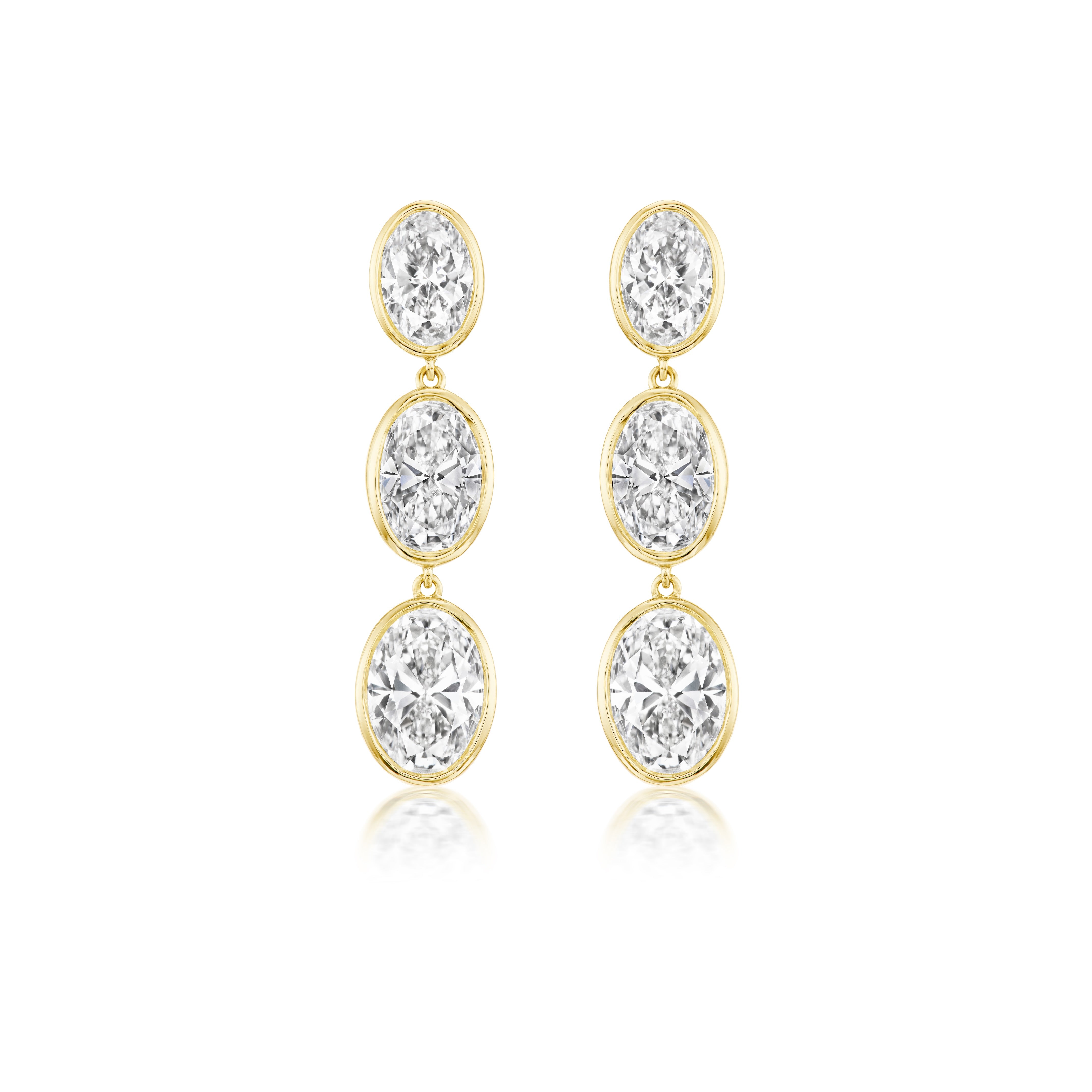 Graduating Bezel Set Oval Diamond Drop Earrings in Yellow Gold, each earring showcasing three vertically stacked oval diamonds in bezel settings, displayed on a white background.