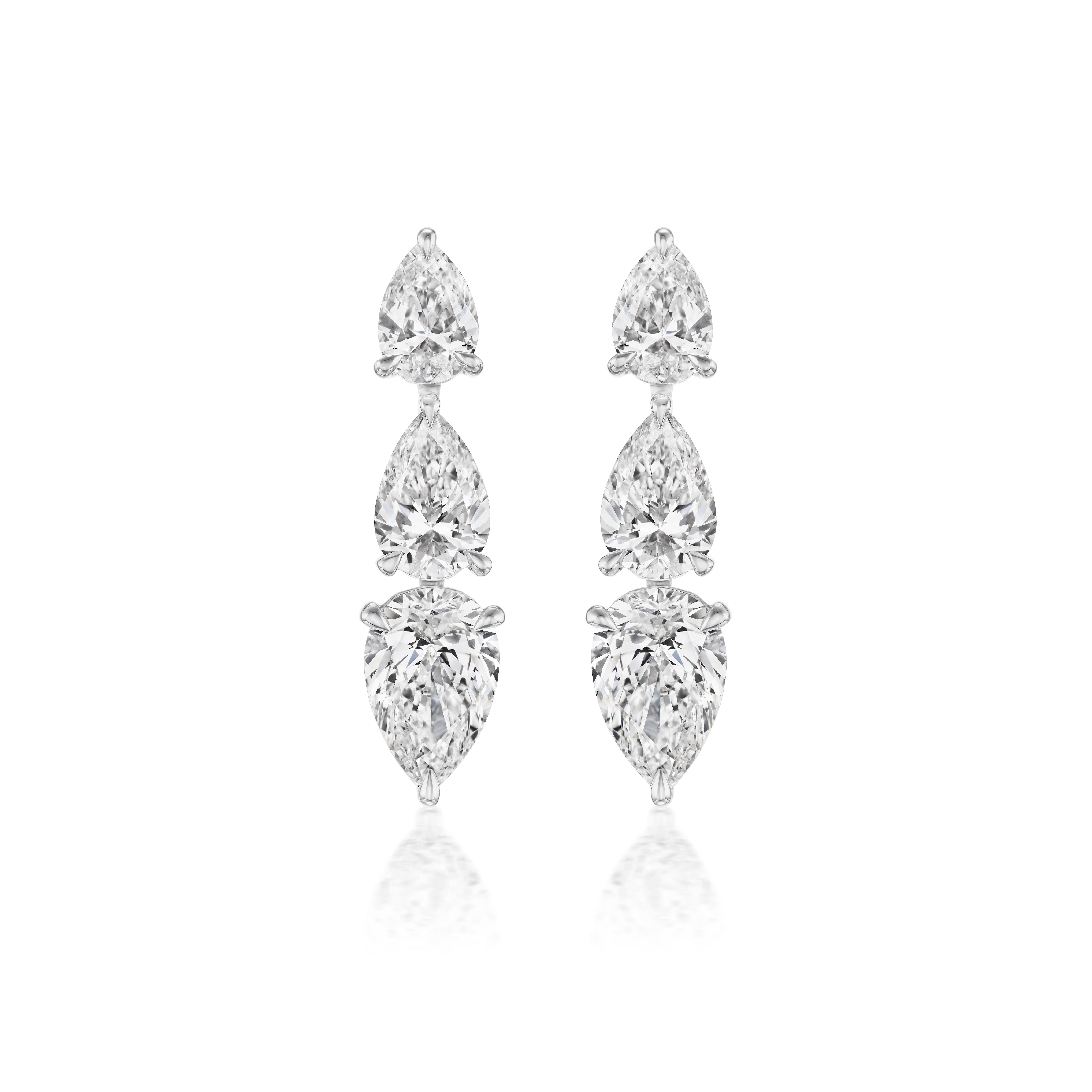 The Inverted Pear Shape Diamond Drop Earrings in White Gold feature three vertically aligned pear-shaped diamonds on each earring, set in a sleek 18K white gold design against a white background.