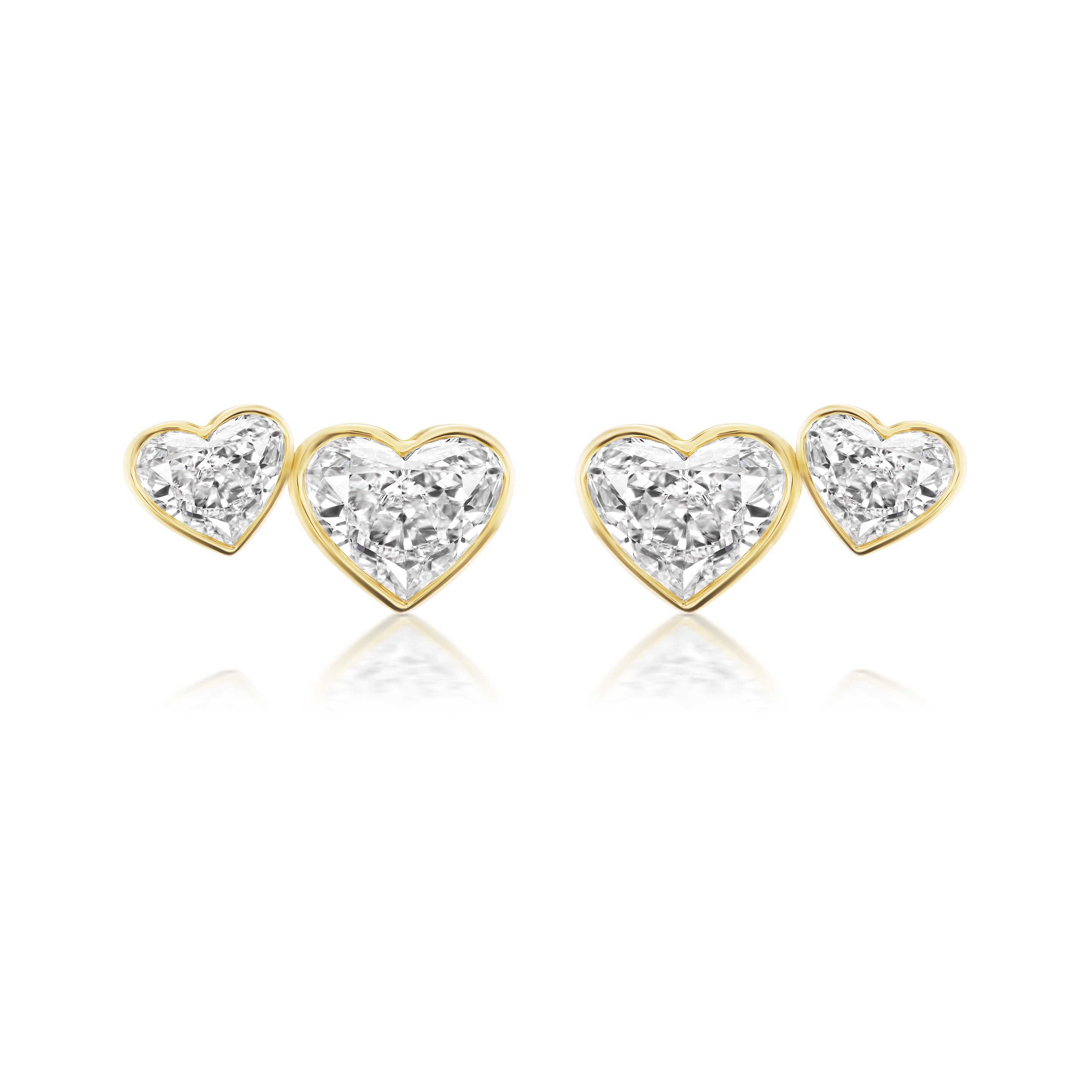 The Bezel Set Heart Shape Diamond Duo Studs are a set of four heart-shaped studs outlined in 18k yellow gold and set with sparkling diamonds, shown on a white background.