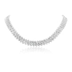 The Bezel Set Chevron Diamond Tennis Necklace in White Gold features a repeating chevron pattern of rectangular links, crafted in 18K white gold and shown on a reflective white background.