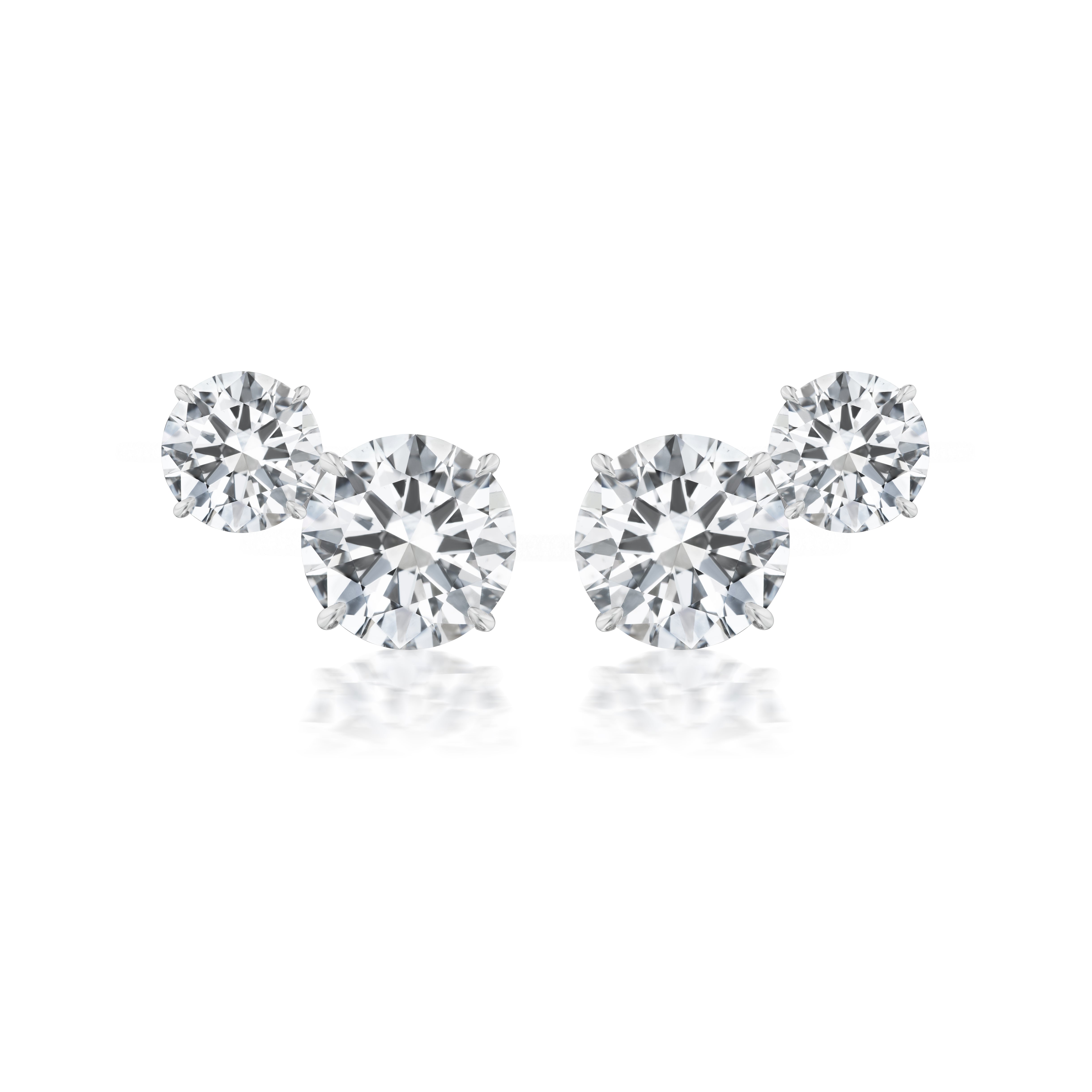 The Duo Round Diamond Studs feature two round brilliant diamonds of different sizes, set in 18k white gold, with the smaller diamond placed slightly above and beside the larger one on each stud.