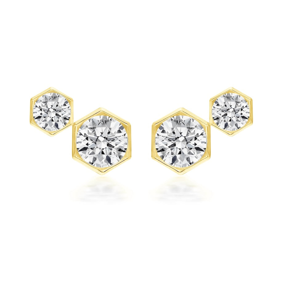 The Hexagon Bezel Set Round Diamond Duo Studs are 18k gold earrings featuring round brilliant diamonds in hexagonal frames, arranged in a chic geometric design.