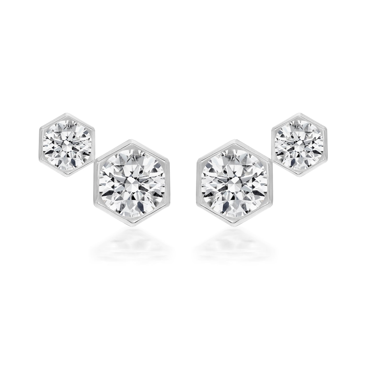 The Hexagon Bezel Set Round Diamond Duo Studs feature two clear round diamonds in hexagonal frames of different sizes, set side by side and expertly crafted in 18k gold.