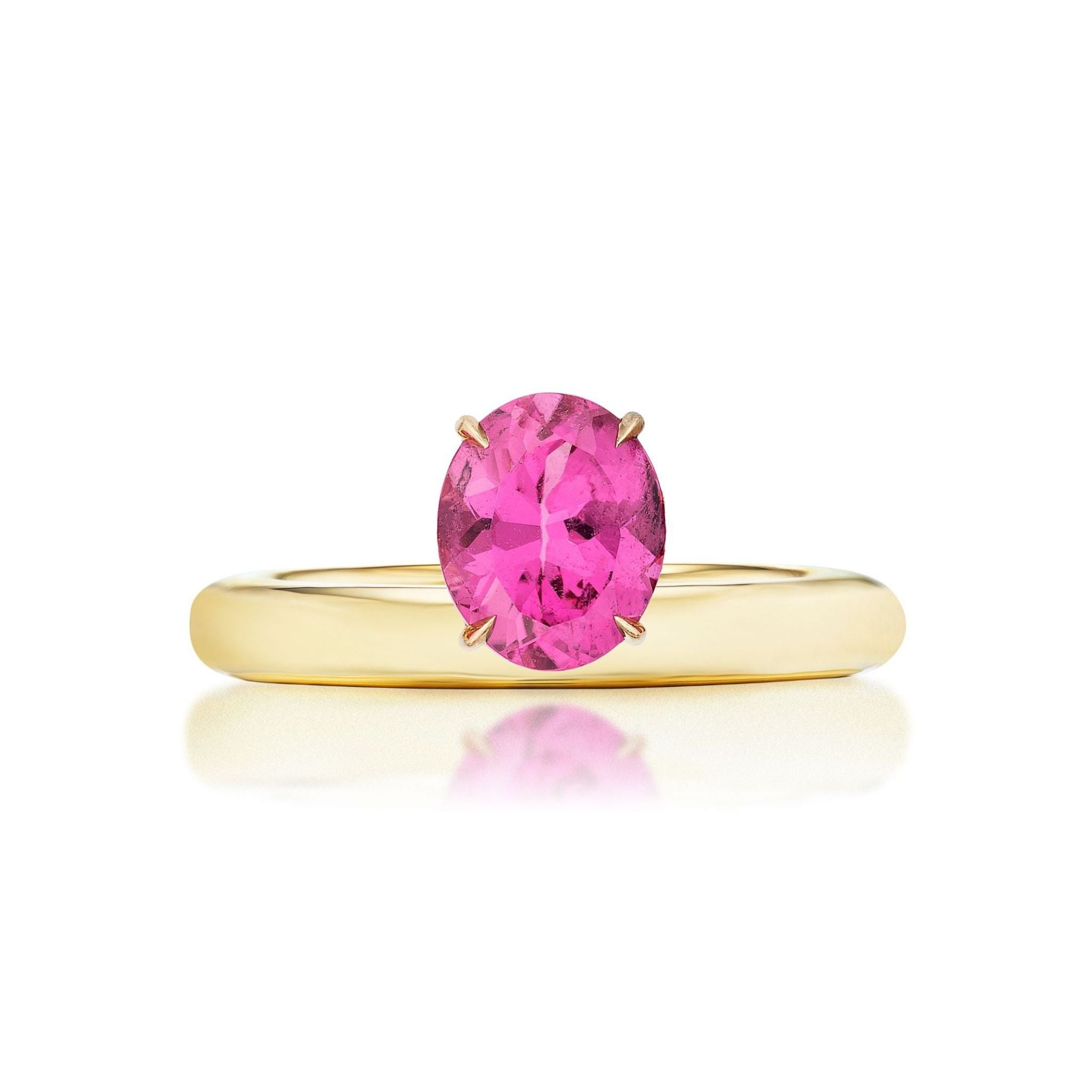 The North-South Set Pinky Ring in Yellow Gold with Oval Pink Sapphire showcases a simple 18k yellow gold band and a prong-set oval-cut hot pink sapphire, presented against a white background.
