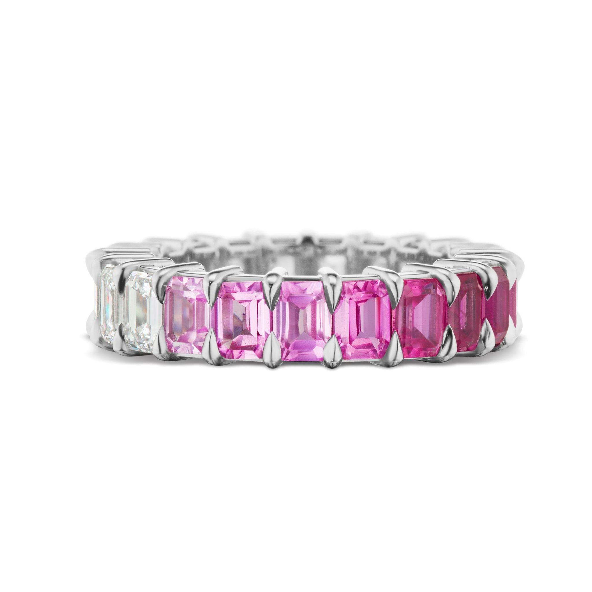 The Ombré Eternity Band features alternating emerald cut pink sapphires and white diamonds, displayed upright on a white background.