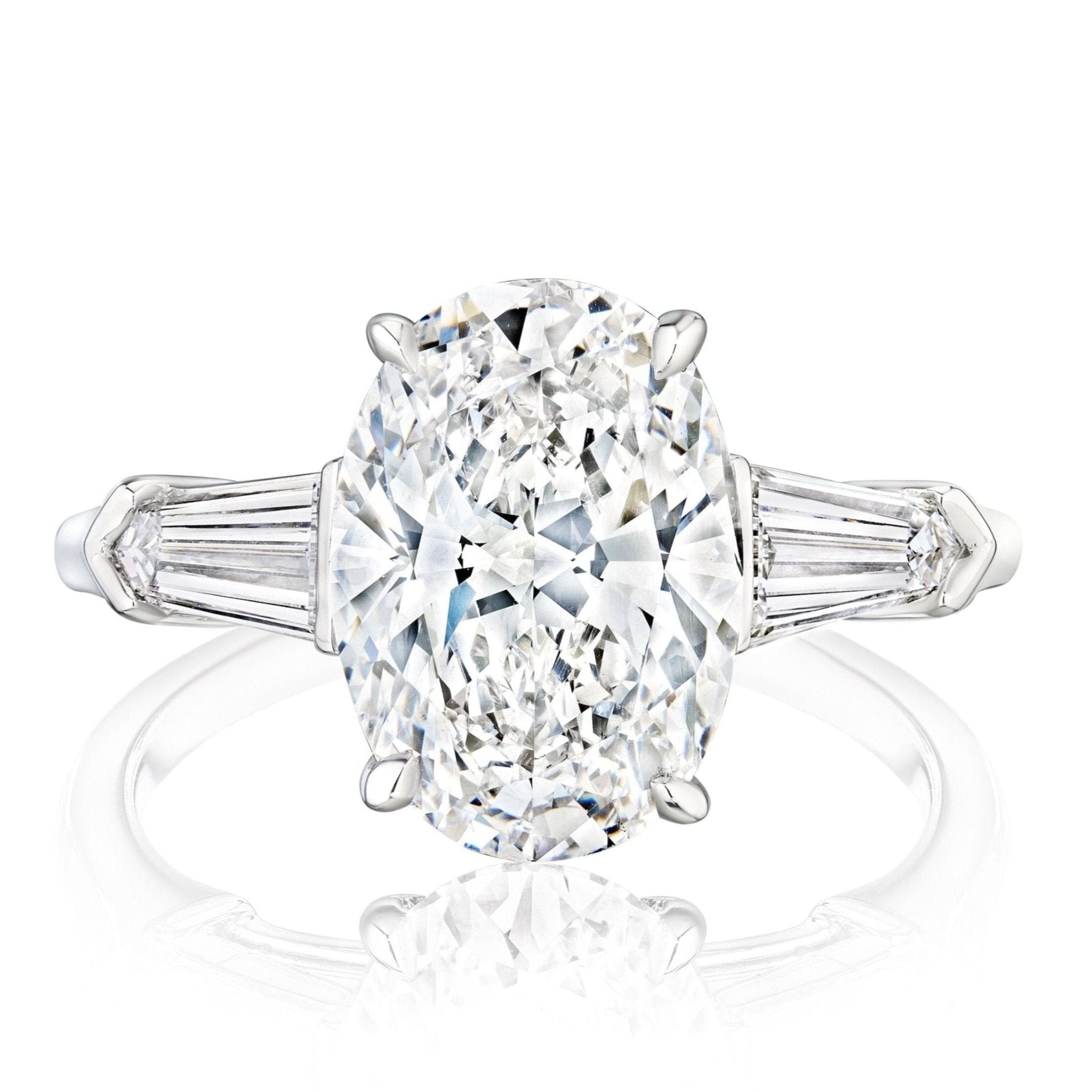 The Oval Shape Diamond Engagement Ring with Bullet Side Stones features a large oval diamond center accented by tapered side stones, all set in elegant white gold prongs.