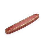 A long, oval-shaped red case with gold trim, shown closed against a white background, for the Cartier Art Deco Sapphire and Diamond Watch.