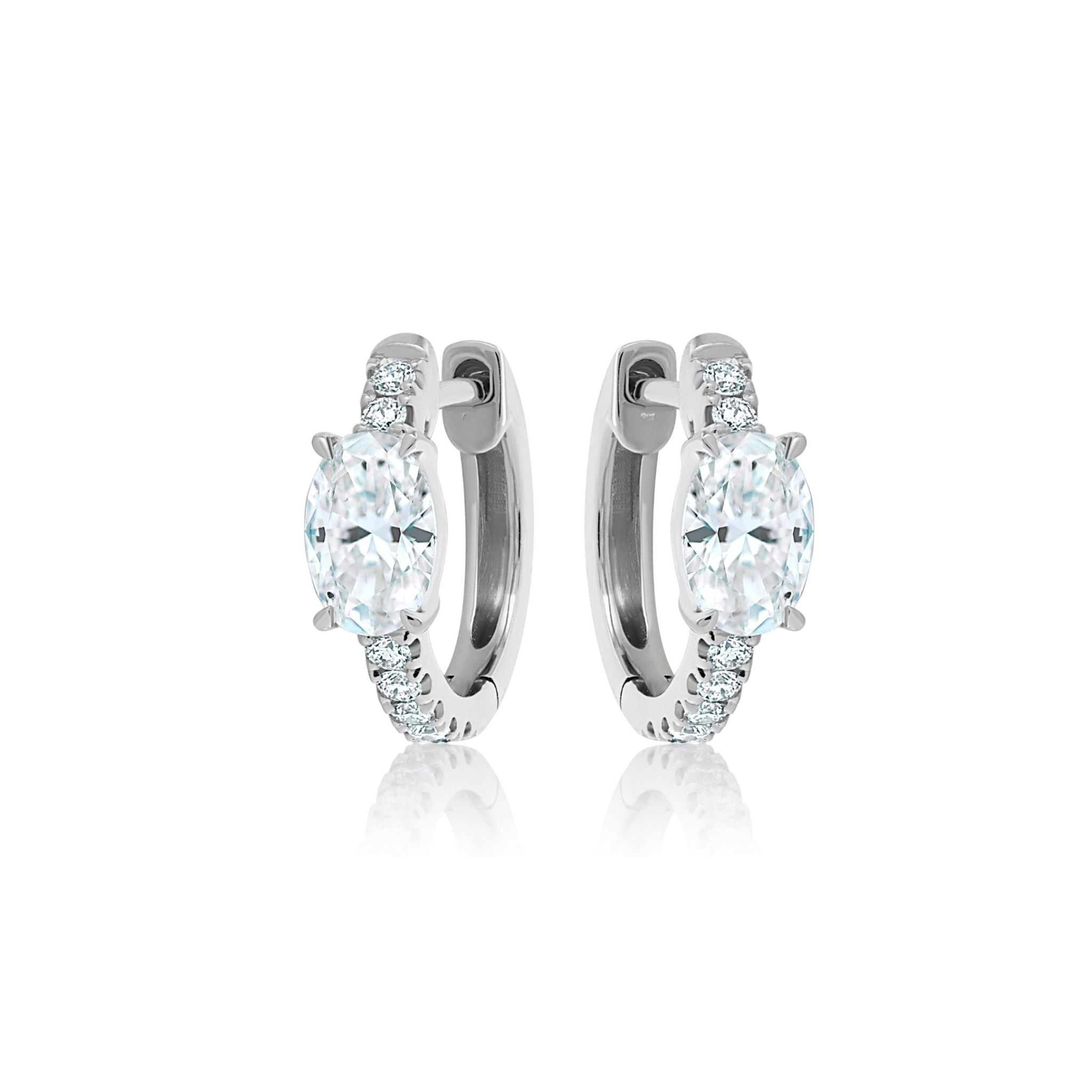 Pavé Huggies with Oval Shape Diamond in White Gold shown on a white background, featuring large oval-cut SI clarity diamonds at the center and smaller round stones accenting the front of each silver hoop.