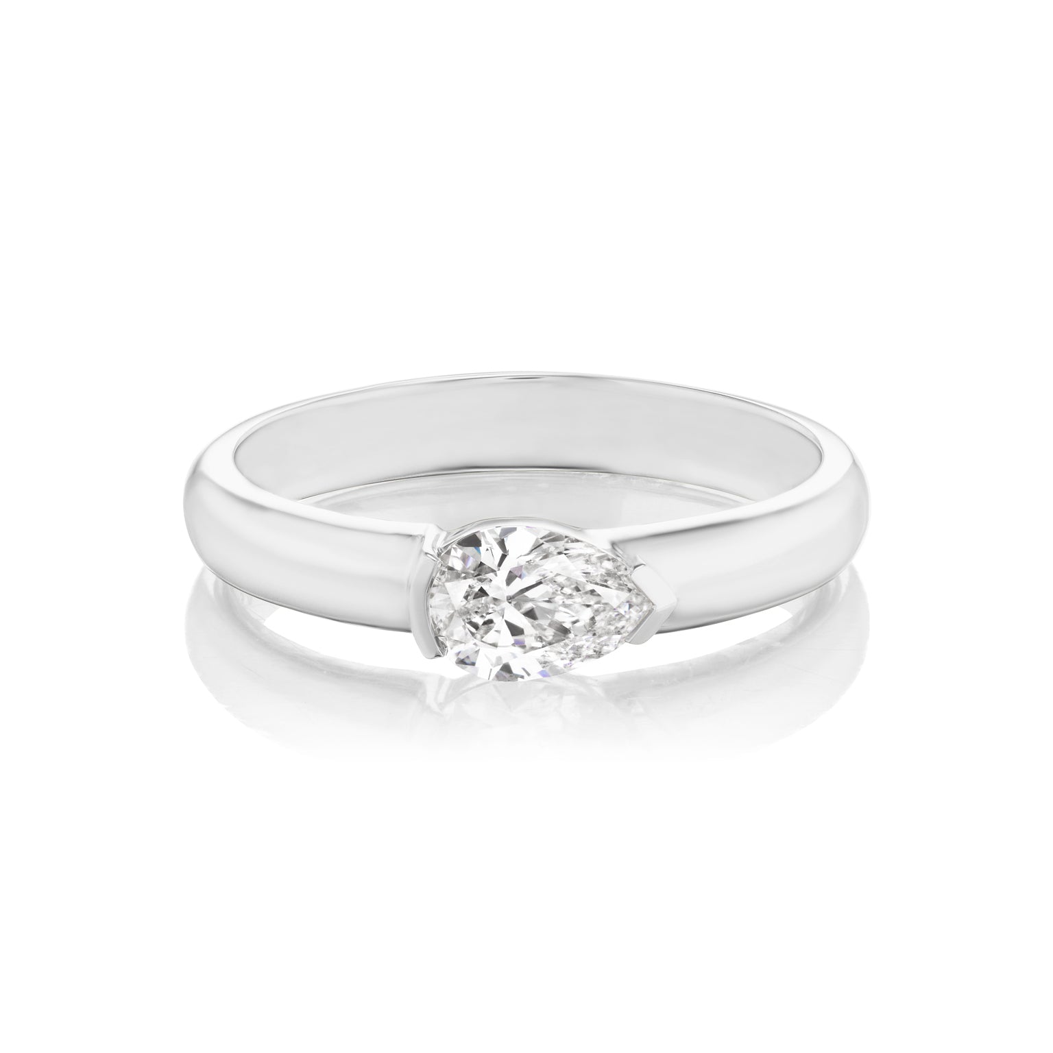 The East-West Pear Diamond Solitaire Band features a clear pear-shaped center stone set horizontally on a sleek 18k gold band, shown on a white background with a subtle reflection.