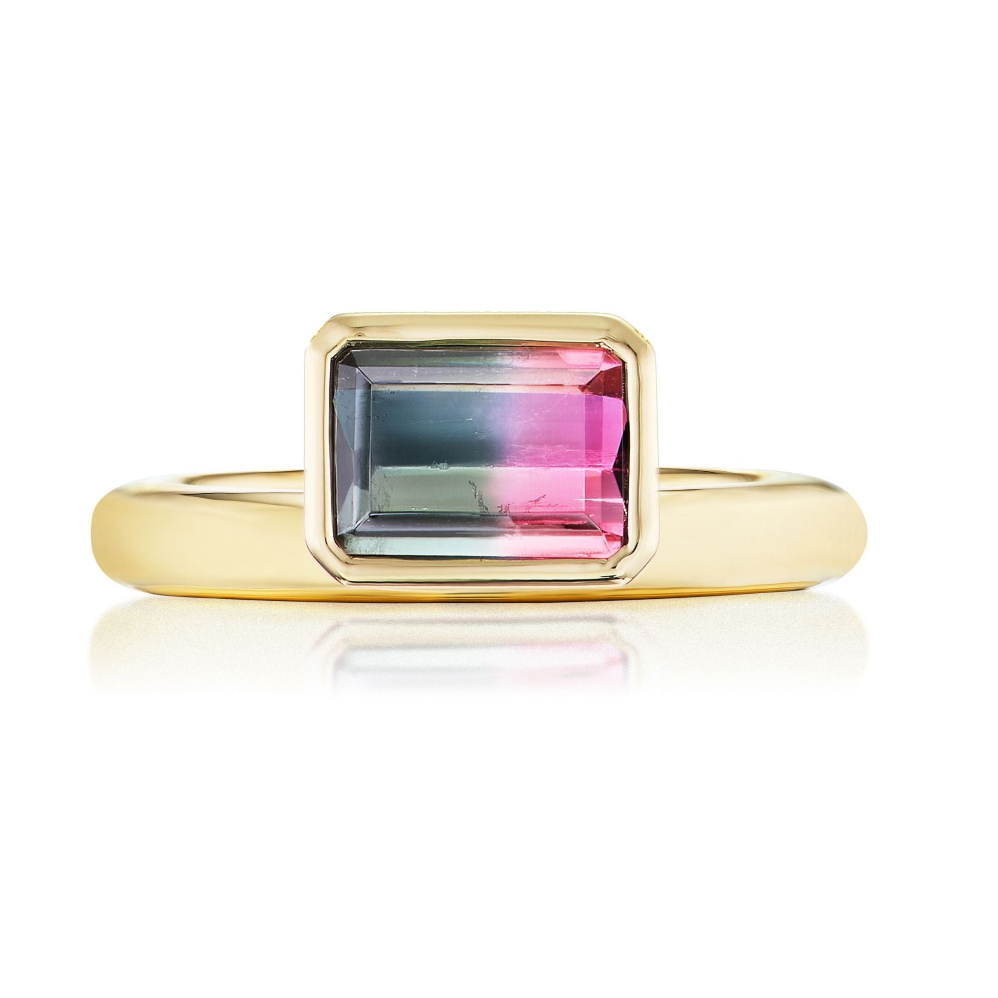 The Pinky Ring in Yellow Gold features an emerald cut watermelon tourmaline with green and pink hues, set in a simple bezel setting.