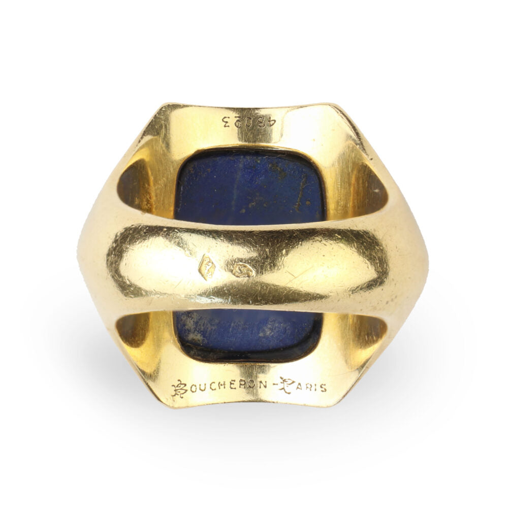 The Boucheron Lapis Lazuli and Gold Ring features an 18k gold geometric design with a rectangular blue lapis stone at its center, and is inscribed with BOUCHERON PARIS and a serial number inside the band.