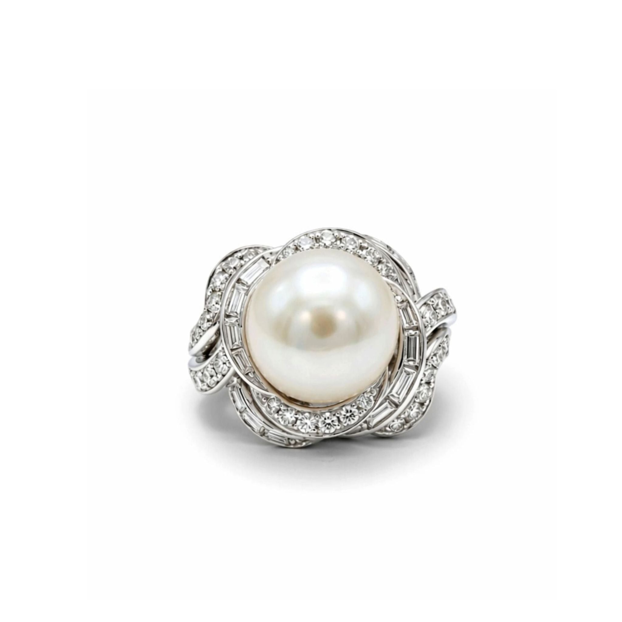 The David Webb Pearl and Diamond Ring showcases a large cultured pearl at its center, encircled by an elaborate swirl of small round and baguette diamond accents set in silver.