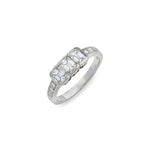 Introducing the 1950s Diamond Ring: a platinum piece showcasing three rectangular-shaped diamonds at its center, accented by smaller stones gracefully set along the band. This vintage-inspired ring is captured against a white background.