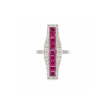 A platinum ring named the Ruby and Diamond Ring, showcasing a vertical row of square-cut rubies bordered by small diamonds, set on a wide, elongated geometric face with a thin band reminiscent of old European-cut diamond styles.