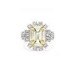The Yellow Sapphire and Diamond Ring features a large rectangular yellow sapphire surrounded by a sunburst halo of round and baguette diamonds, all set in platinum.