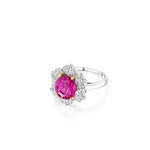 A breathtaking Vintage Oscar Heyman & Brothers Pink Sapphire and Diamond Ring showcasing a prominent round Ceylon pink sapphire at its center, encircled by a halo of brilliant white diamonds in an elegant floral arrangement, all beautifully set on polished silver.