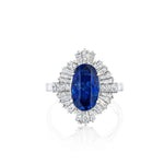 Presenting the Sapphire and Diamond Ring: a platinum piece showcasing an oval Ceylon sapphire center stone encircled by a halo of baguette and round diamonds, set on a simple band and accompanied by a GIA report.