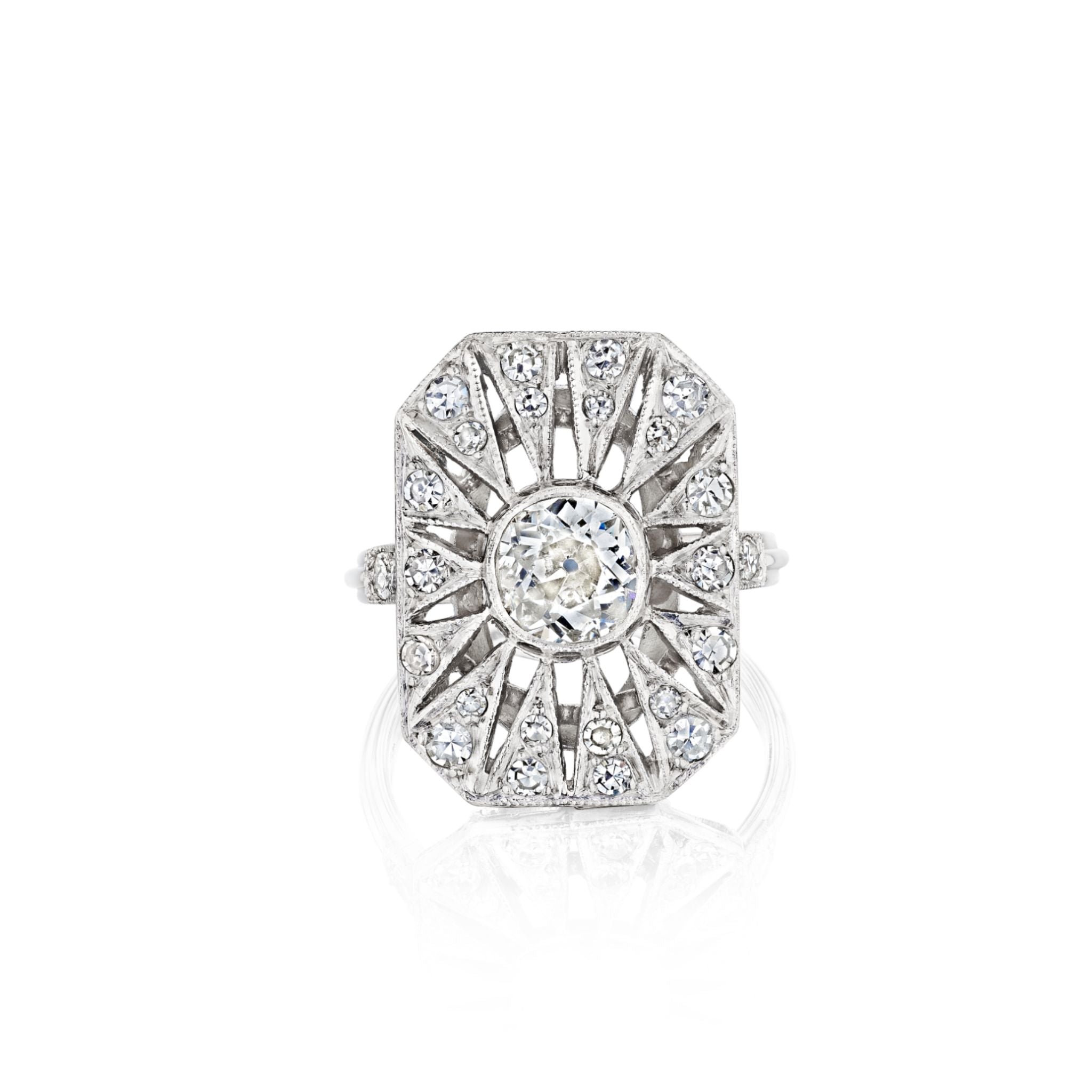 The Art Deco Diamond Ring is an ornate platinum piece with a rectangular sunburst-patterned design, showcasing a central old European-cut diamond surrounded by smaller diamonds—a true reflection of the timeless elegance found in vintage masterpieces from 1925.