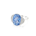 1930s Sapphire and Diamond Ring displayed on a white background, featuring a large oval Ceylon sapphire at the center, flanked by clusters of small rose-cut diamonds on each side.