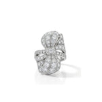 The Diamond Ring, crafted from white gold and designed in the shape of a bow, is embellished with numerous sparkling old European diamonds. Displayed upright against a plain white background, it captures the timeless elegance characteristic of 1930s jewelry.