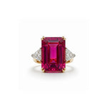 The Pink Tourmaline and Diamond Ring is crafted in gold, showcasing a prominent emerald-cut pink tourmaline at its center, accented by two triangular white diamonds on either side, set against a white background.