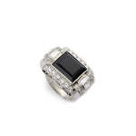 The Onyx and Diamond Ring features a platinum band set with a prominent emerald-cut onyx at its center, accented by rows of small round diamonds along the band.