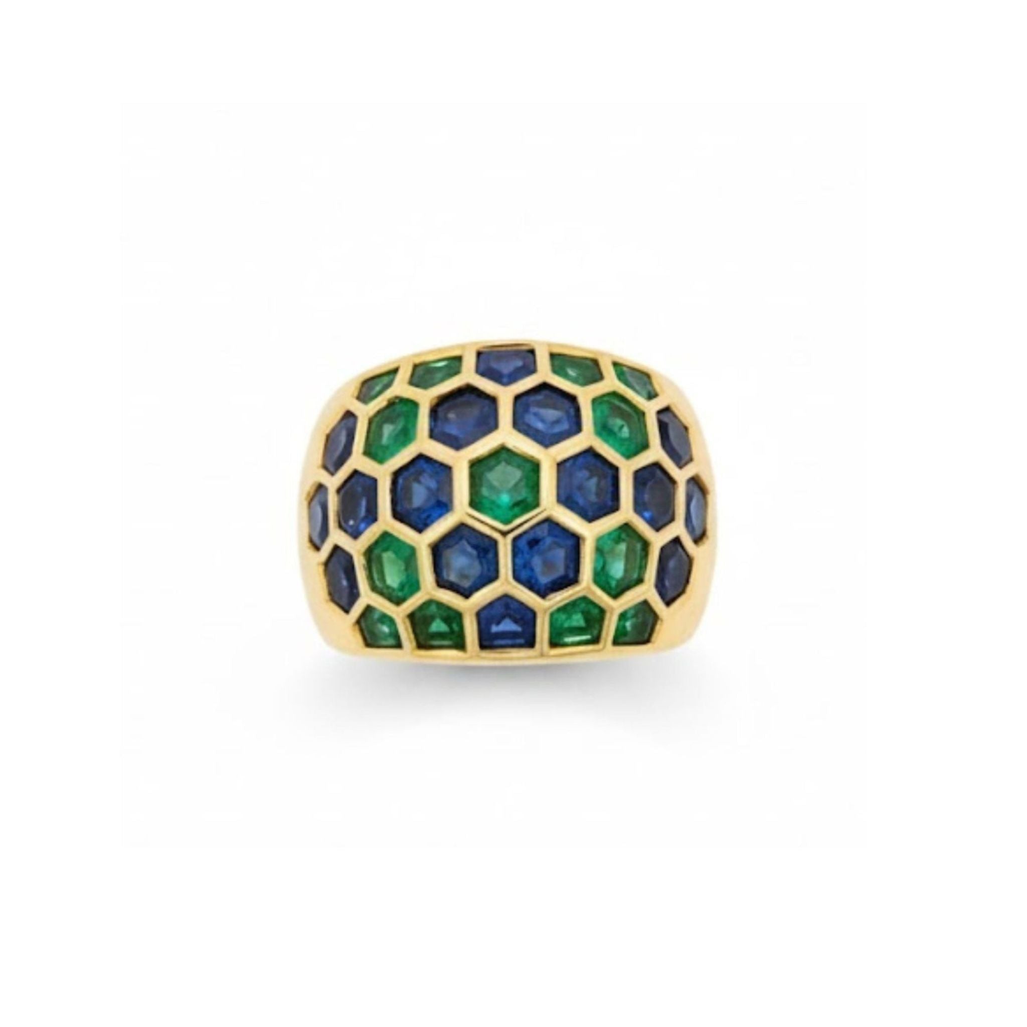 The Sabbadini Emerald and Sapphire Ring features brilliant blue sapphires and vibrant green emeralds arranged in a mosaic honeycomb pattern, elegantly set in 18K yellow gold.