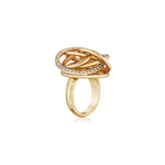 The Gold and Diamond Ring showcases an intricate knot design in 18K gold, highlighted by a circle of small, sparkling white gemstones evocative of pavé diamonds, displayed on a plain white background.