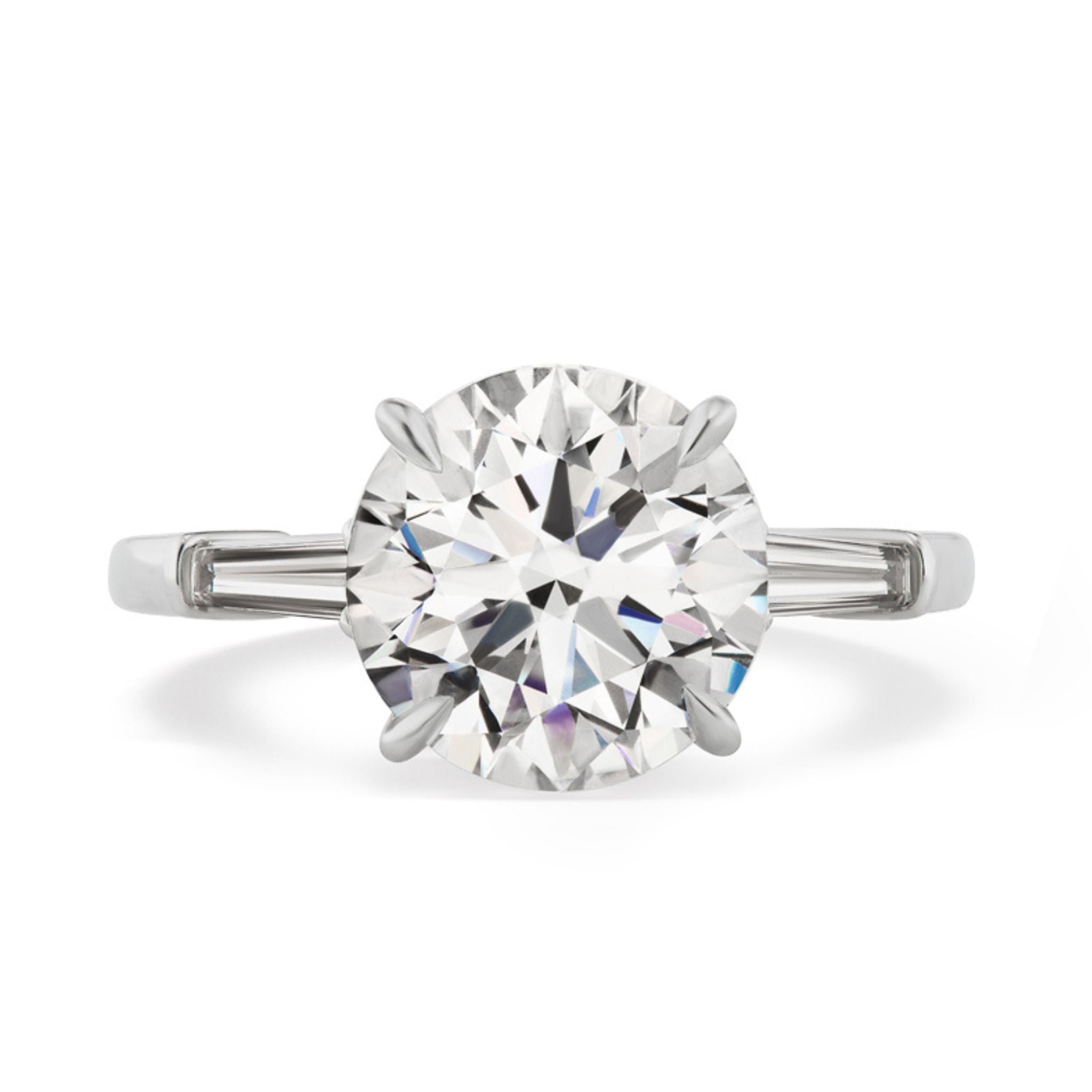 The Round Brilliant Diamond Engagement Ring with Tapered Baguette Side Stones showcases a stunning round center diamond accented by two tapered baguette diamonds—an elegant and timeless bridal ring choice.
