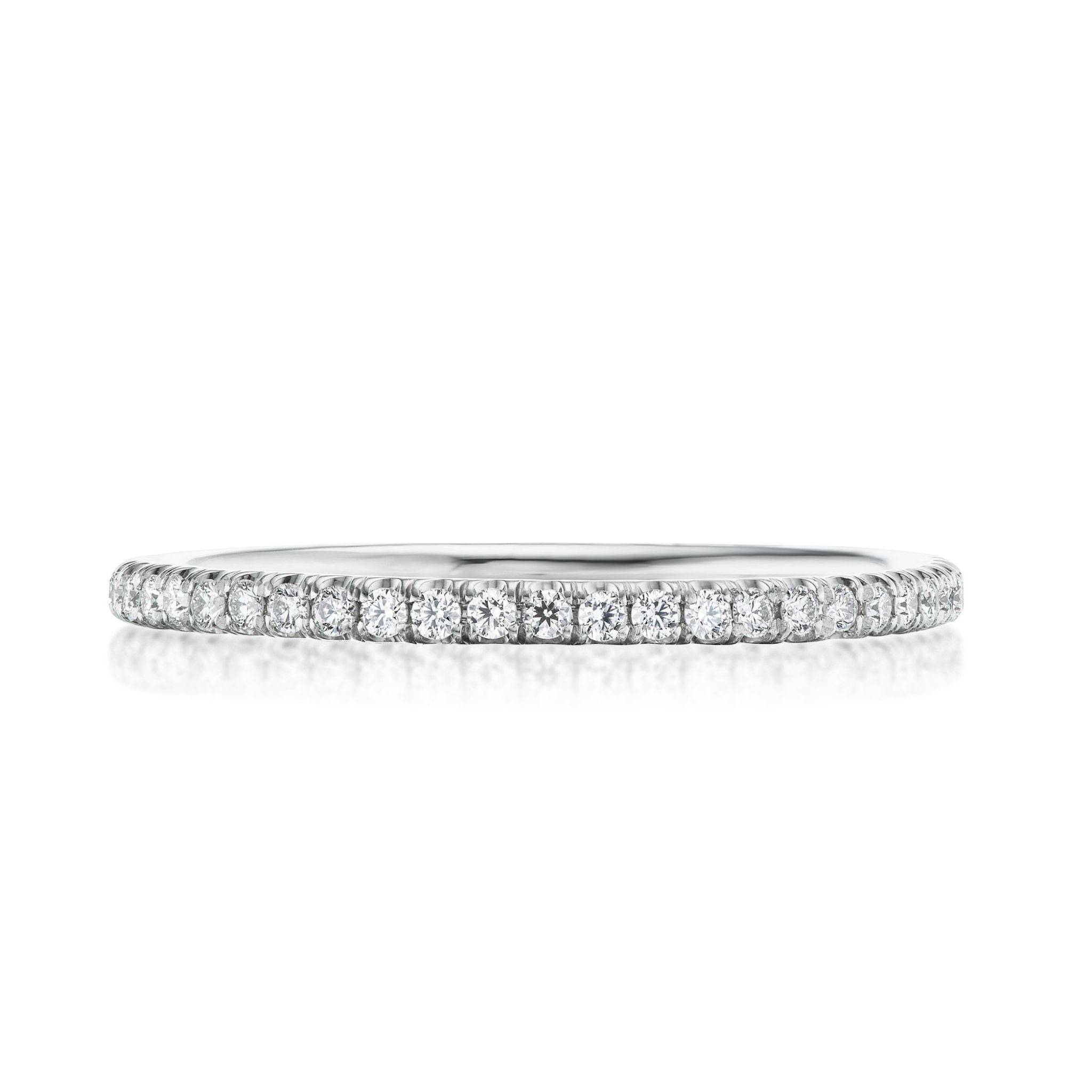 The Round Diamond Eternity Band is a delicate 18K white gold ring with a continuous row of small, round diamonds set in a thin band, shown on a white background.