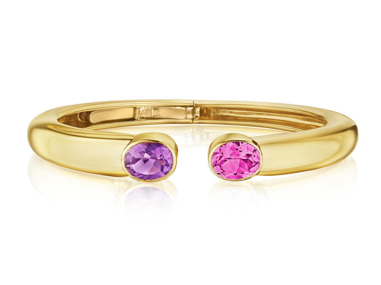 The Bezel Set Open Space bangle features an oval sapphire and amethyst bezel set on the open ends of an 18K yellow gold bracelet.