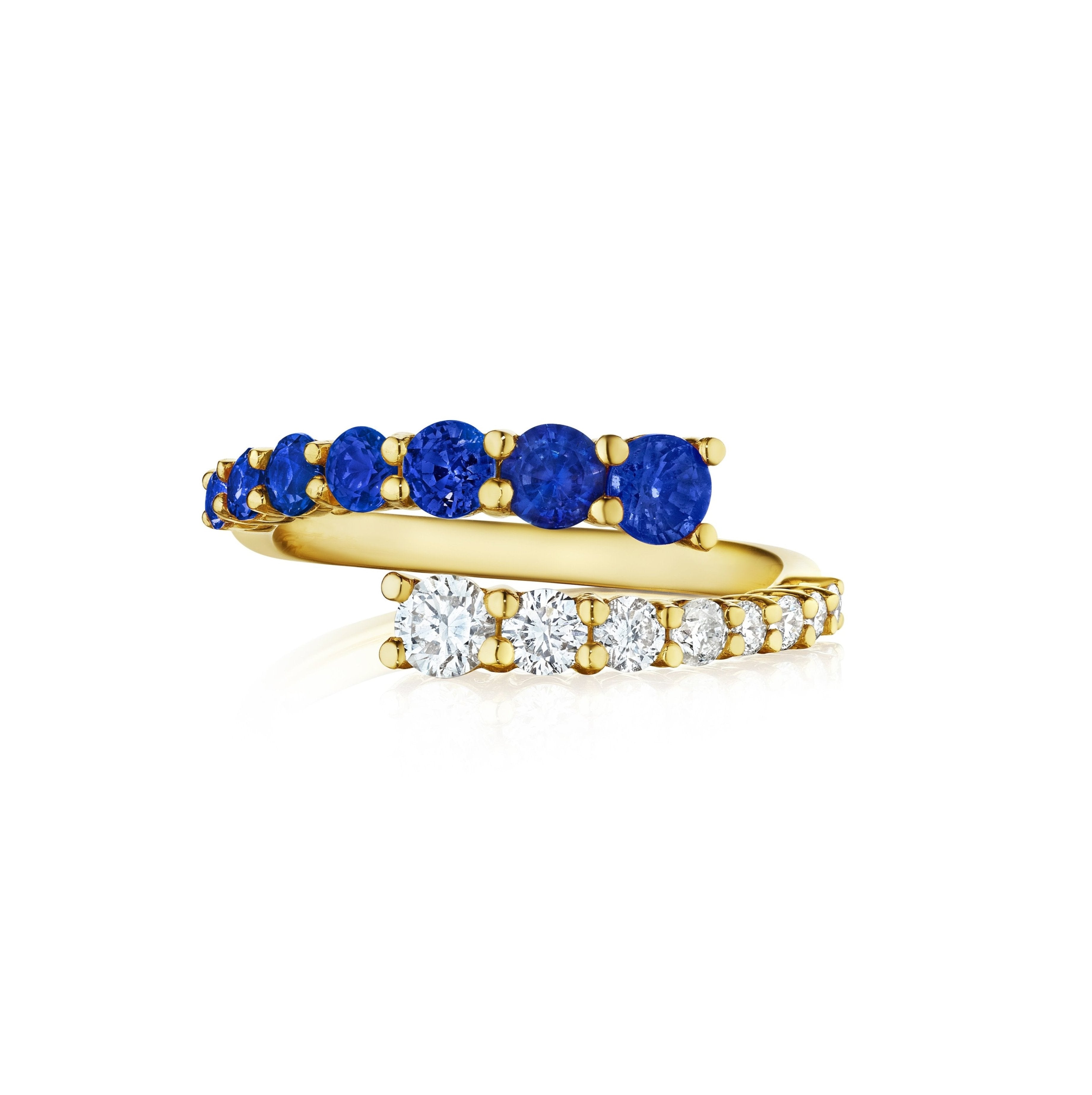 The Open Space Ring, crafted in 18K yellow gold, features stacked bands—one with round blue sapphires and the other with round diamonds—in a simple, elegant design displayed on a white background.