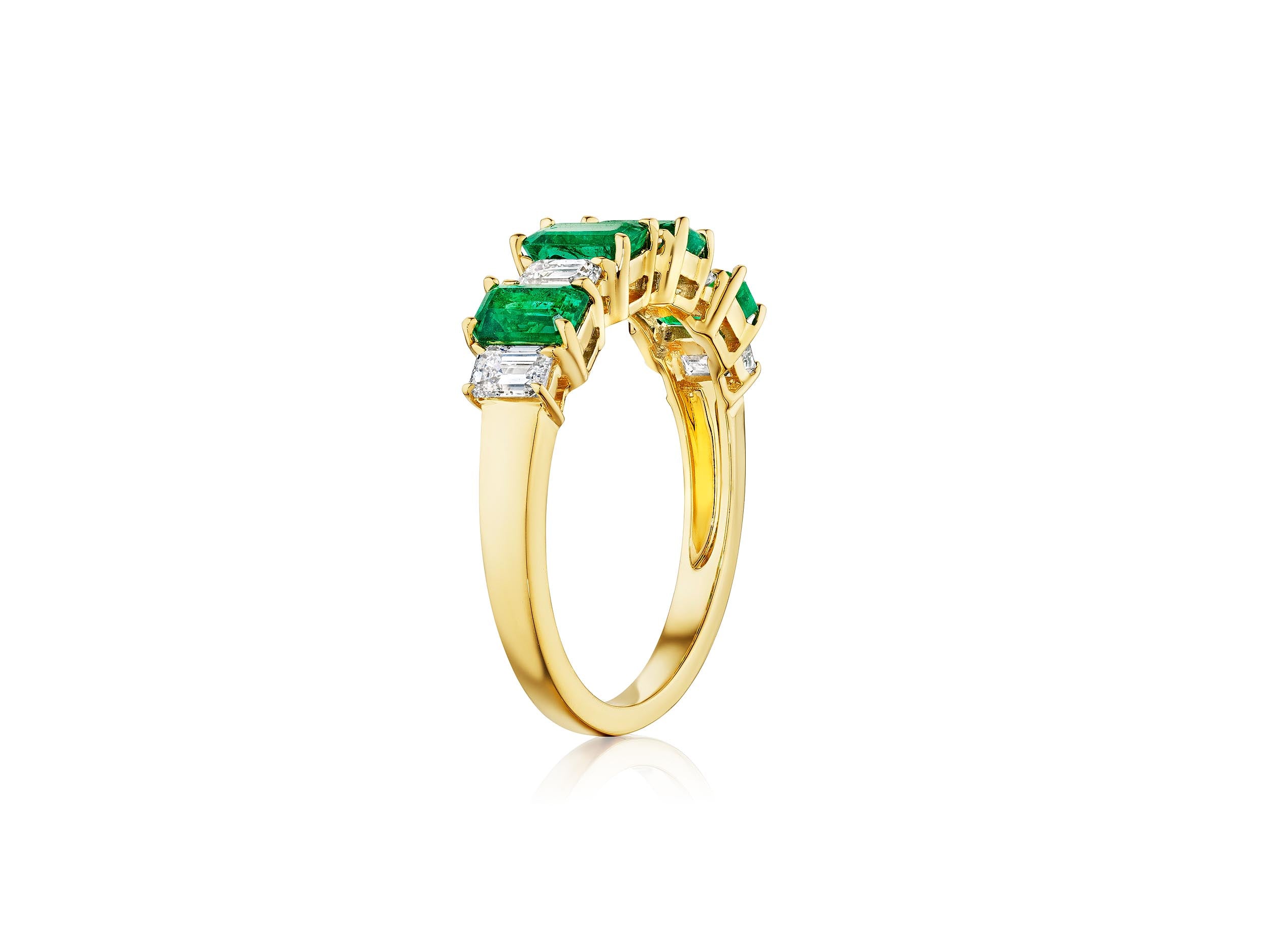 The Chroma Alternating Emerald and Diamond Half Eternity Band showcases rectangular green emeralds and emerald-cut diamonds set in 18K gold, arranged in a row along the band and displayed on a white background.