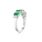 The Chroma Alternating Emerald and Diamond Half Eternity Band is a silver ring with five rectangular green emeralds separated by small clear diamonds, shown on a white background.