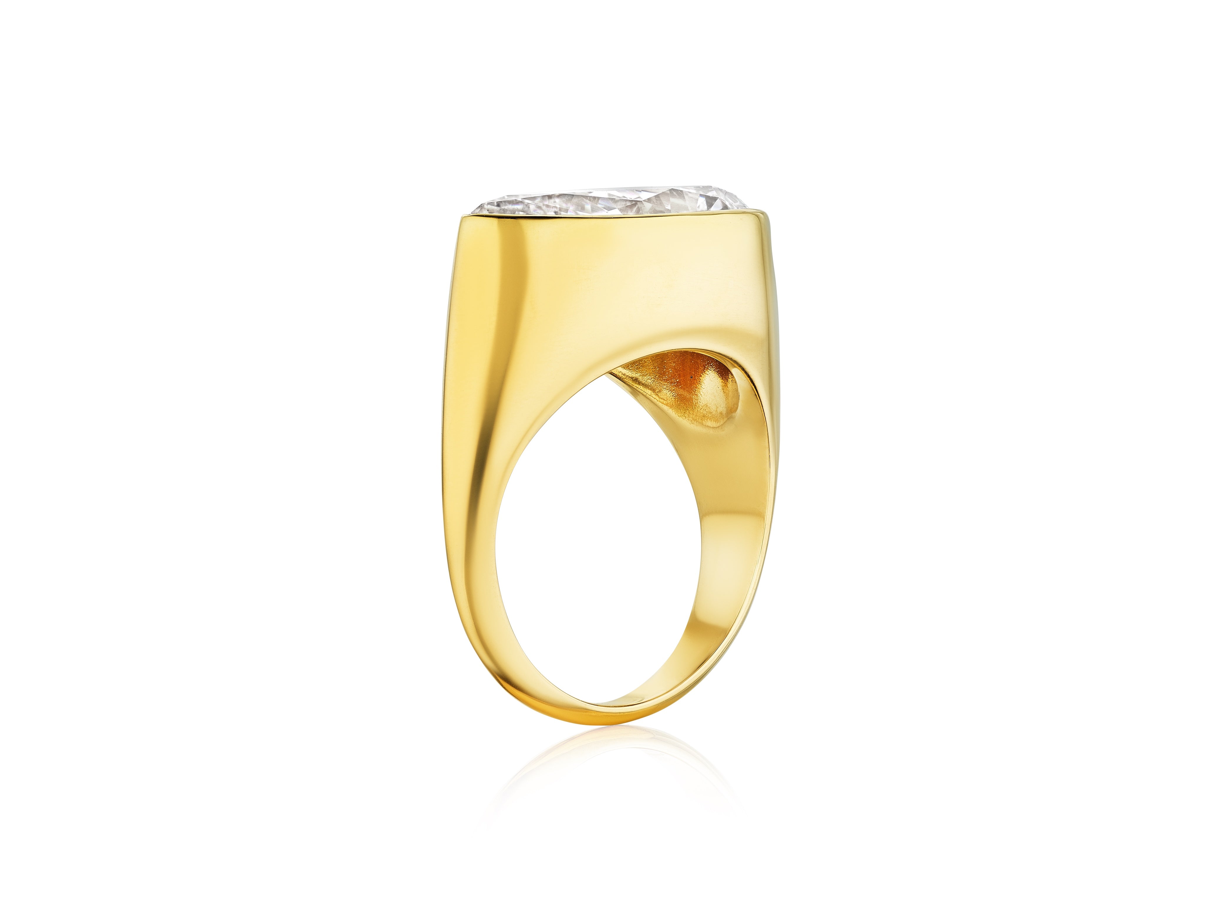 The East-West Bezel Set Pear Shape Diamond Ring in yellow gold features a thick band and a large, clear pear-shaped diamond set in a bezel, shown from the side against a white background.