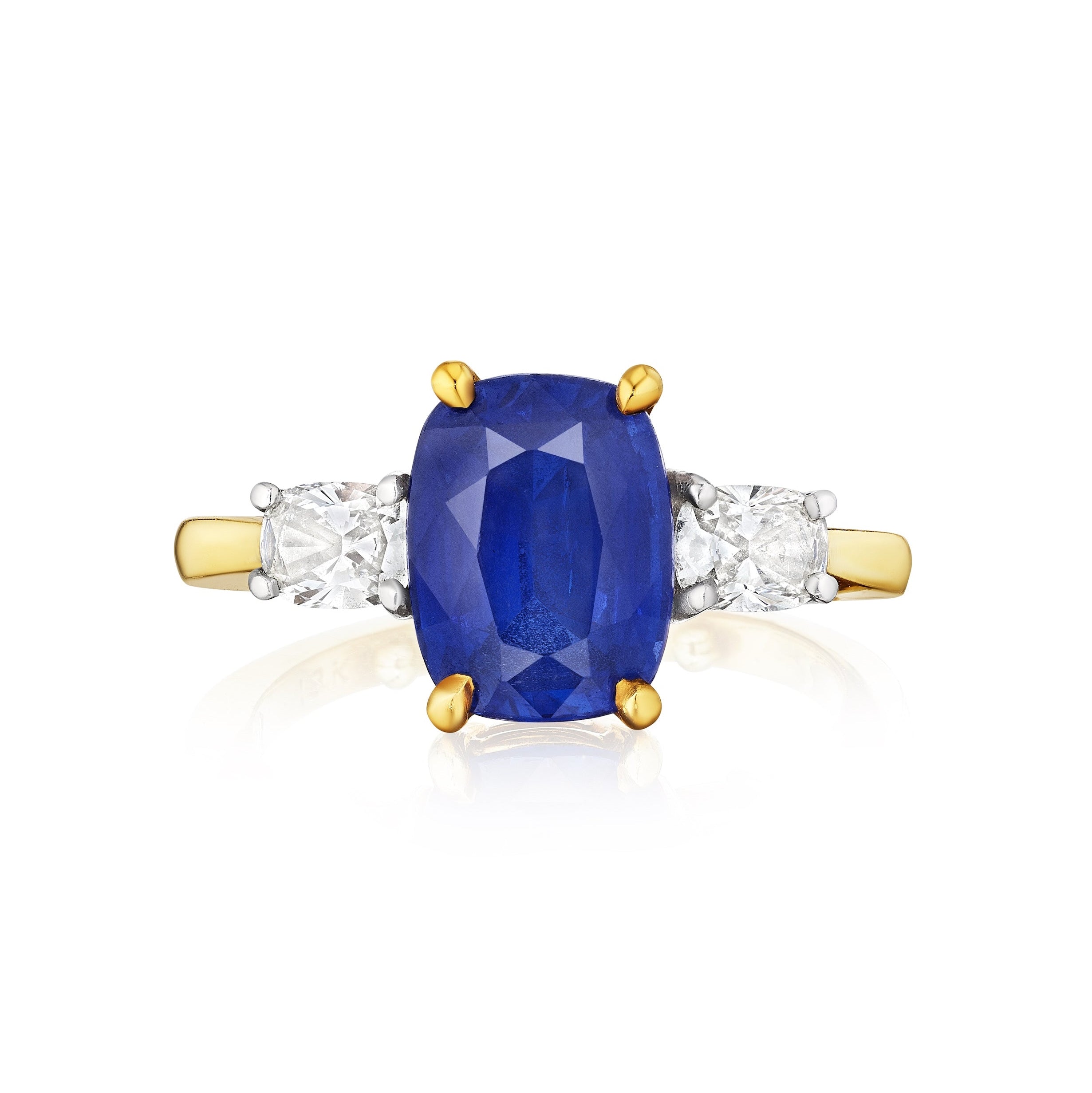 A yellow gold engagement ring featuring a large cushion cut blue sapphire center stone, accented by oval diamond side stones.