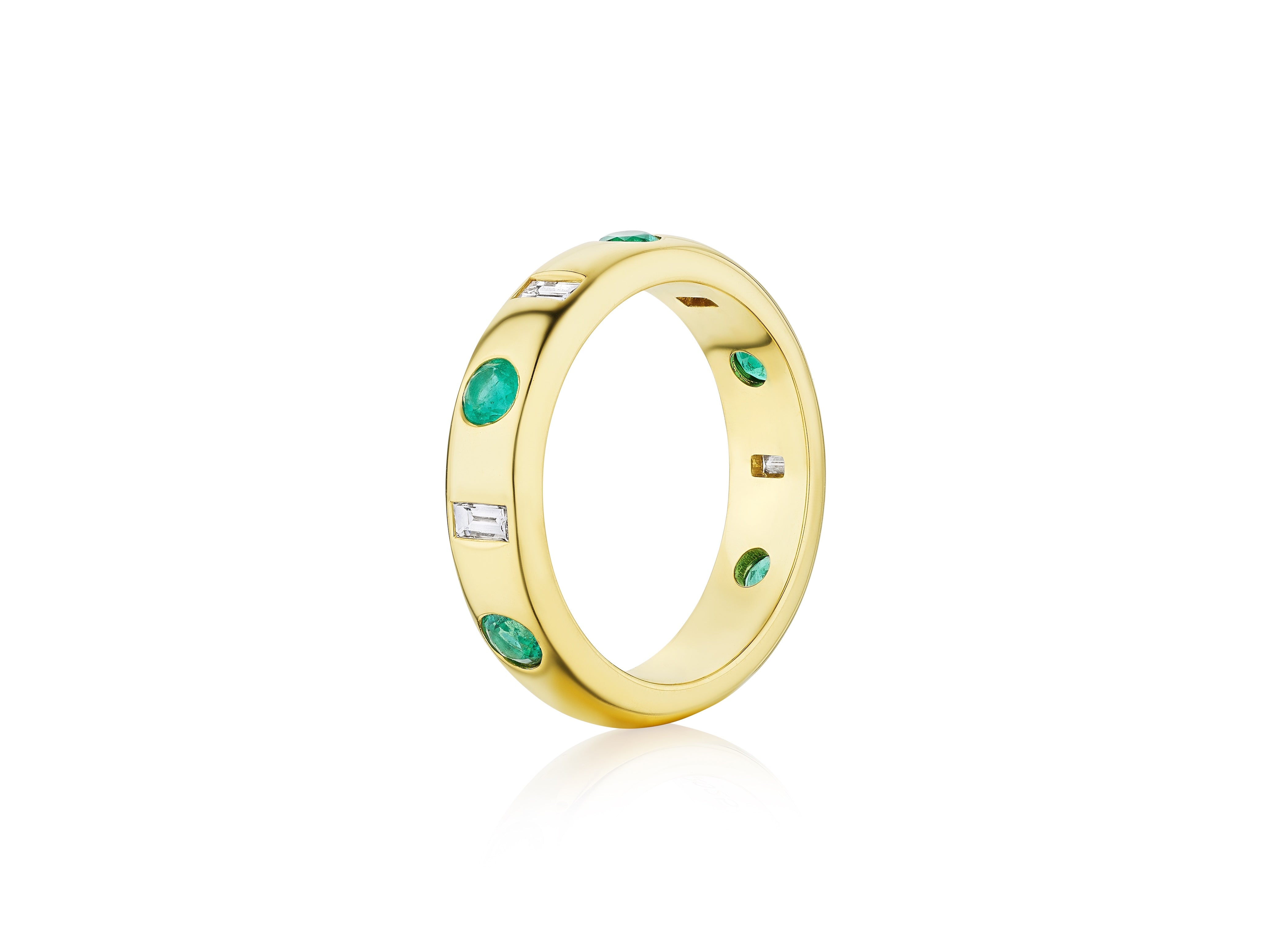 The Bespoke Burnish Set Baguette Diamond and Round Emerald Band in Yellow Gold features round emeralds and sparkling baguette diamonds set evenly around the ring, displayed on a white background.