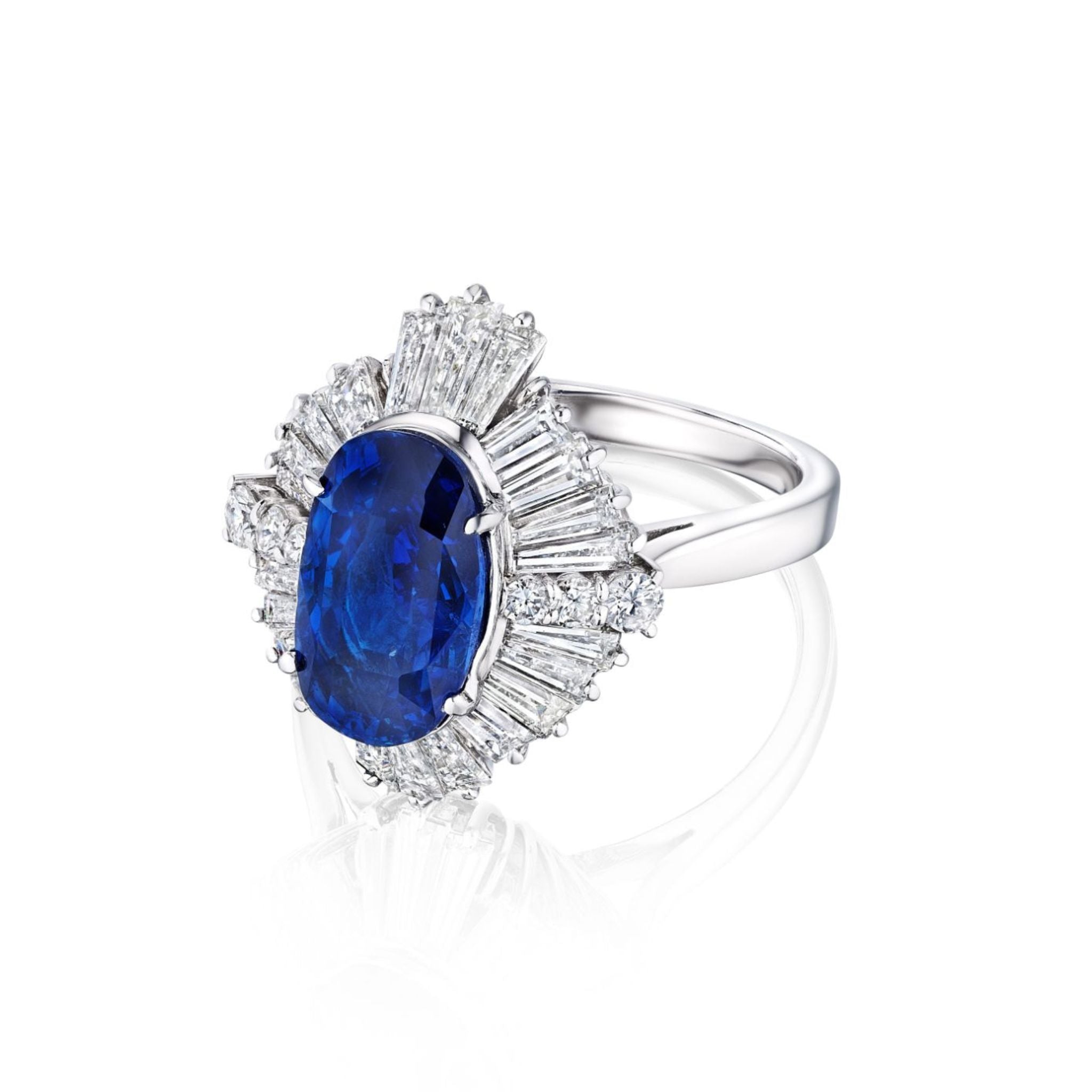 The Sapphire and Diamond Ring features a platinum band with a large oval Ceylon sapphire center, accented by tapered and round diamonds in a starburst design, and comes with a GIA report.