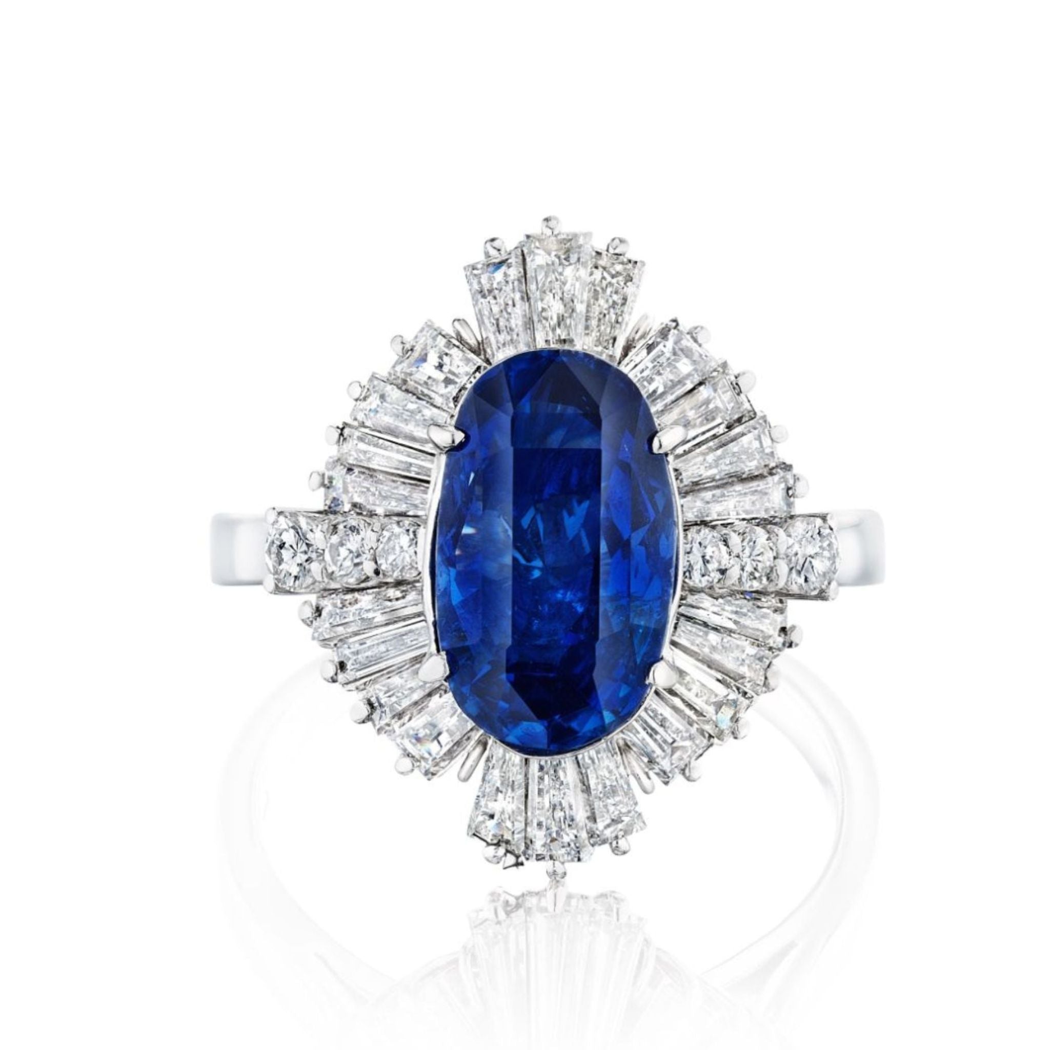 The Sapphire and Diamond Ring showcases a large oval Ceylon sapphire set in platinum, encircled by round and tapered baguette white diamonds in a radiant halo, and comes with a GIA authenticity report.