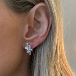 Close-up of a person’s ear wearing Tetris Studs with Baguette Diamonds in White Gold, totaling 2.50ctw in rectangular clear stones. The unique geometric stacked design stands out against blonde hair.