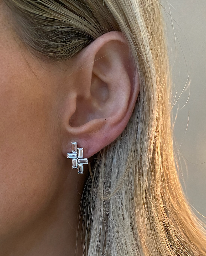 Close-up of a person’s ear wearing Tetris Studs with Baguette Diamonds in White Gold, totaling 2.50ctw in rectangular clear stones. The unique geometric stacked design stands out against blonde hair.