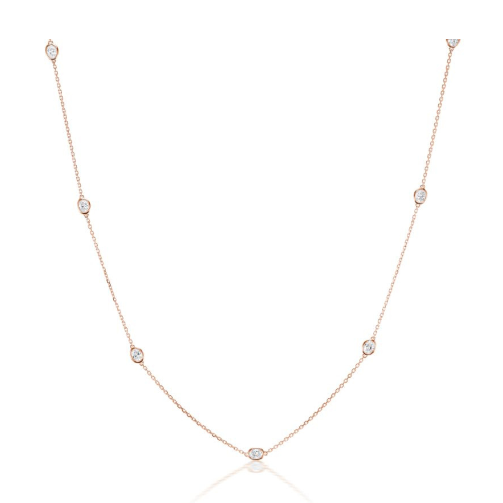 The Serpentine Station Necklace with Oval Diamonds features delicate 18K rose gold and oval diamonds evenly spaced along the chain, displayed on a white background.