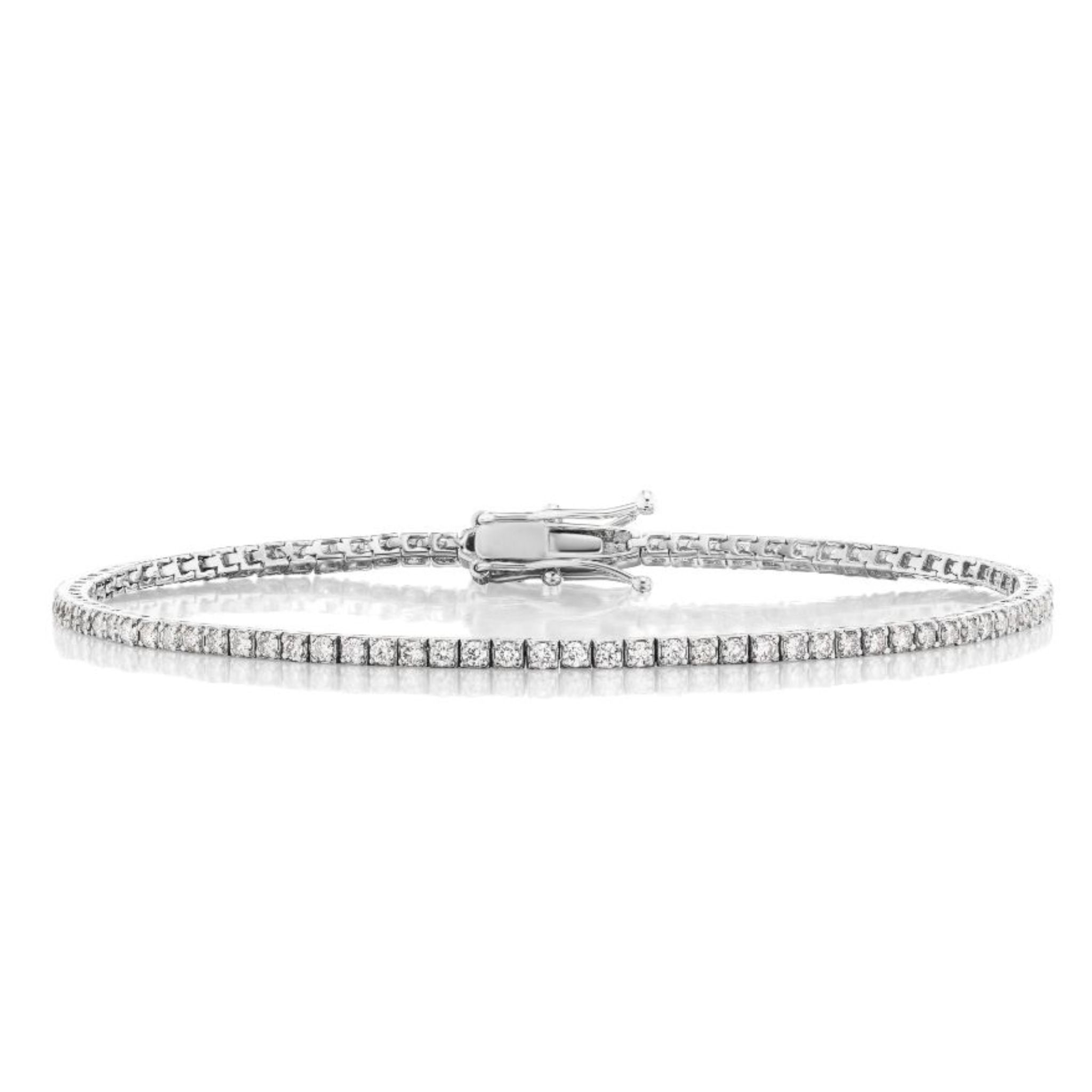 The Skinny Round Brilliant Diamond Tennis Bracelet, crafted in white gold, features a continuous row of small round brilliant diamonds and a secure clasp. It is elegantly displayed against a white background.