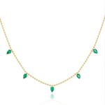 The Spike Necklace in Yellow Gold with Pear Emeralds features five evenly spaced pear-shaped emeralds in 18K yellow gold. Its minimalist design highlights the elegant teardrop gems for a refined, sophisticated look.